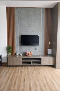 a living room with a television on a wall at Valentin Motel 2 Đà Nẵng in Danang