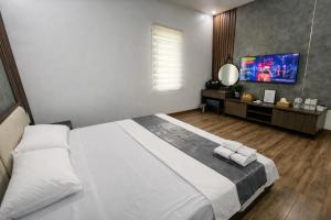 a bedroom with a large white bed and a television at Valentin Motel 2 Đà Nẵng in Danang +11 photos