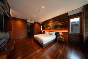 a bedroom with a bed and a television in it at Baan Krai Nao The Riverfront in Bangkok +18 photos