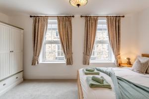 a bedroom with a bed and two windows at 2 Bed in Knaresborough oc-w31758 in Knaresborough