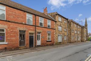 a row of brick buildings on an empty street at 2 Bed in Knaresborough oc-w31758 in Knaresborough