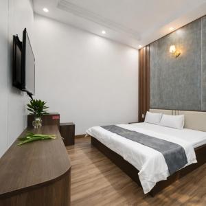 a hotel room with a bed and a television at Valentin Motel 2 Đà Nẵng in Danang