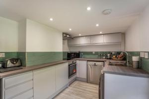 a kitchen with white cabinets and green tiles at 3 Bed in West Lulworth oc-h29362 in West Lulworth
