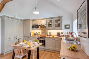 a kitchen with white cabinets and a wooden table at 1 Bed in Sarn oc-y29230 in Bottwnog +11 photos