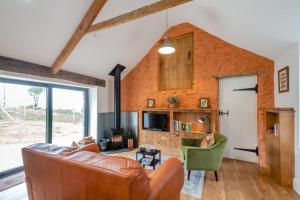 a living room with a leather couch and a tv at 1 Bed in Sarn oc-y29230 in Bottwnog