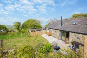 an external view of a stone house with a patio at 1 Bed in Sarn oc-y29230 in Bottwnog