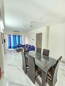 a dining room with a glass table and chairs at Cozy corner in Gurgaon