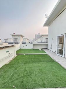 an apartment with a green lawn on the roof at Cozy corner in Gurgaon