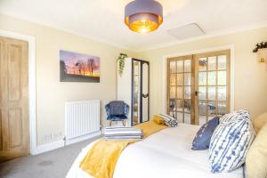 a bedroom with a white bed and a chair at 1 Bed in North Walsham oc-f29380 in North Walsham