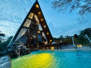 a glass house in the water at night at The Classic Crown Sigiriya in Sigiriya