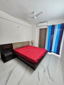a bedroom with a red bed in a room at Cozy corner in Gurgaon