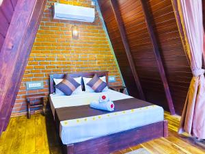 a bed in a room with a brick wall at The Classic Crown Sigiriya in Sigiriya