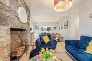 a living room with blue chairs and a stone fireplace at 3 Bed in New Quay oc-c29640 in New Quay