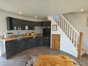a kitchen with black cabinets and a staircase at 1 Bed in Creech oc-g29728 in Kimmeridge