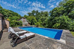 a swimming pool in a yard with a chair next to it at 6 Bed in Robertsbridge oc-d29525 in Brightling