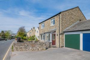 a brick house with a green garage at 3 Bed in Hawes oc-s30429 in Hawes