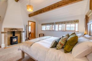 a bedroom with a large white bed and a fireplace at 4 Bed in Cowling oc-h30773 in Cowling