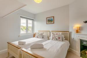 two beds in a white room with a fireplace at 3 Bed in Beer oc-b31132 in Beer