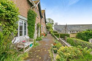 a garden with a bench and a building at 3 Bed in Beer oc-b31132 in Beer