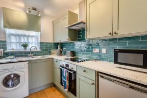 a kitchen with white cabinets and a washer at 2 Bed in Snettisham oc-d31668 in Snettisham +10 photos