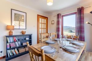 a dining room with a table and a book shelf at 3 Bed in Strathkanaird oc-r30948 in Ullapool