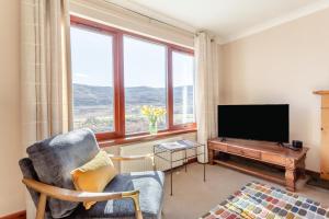 a living room with a television and a chair at 3 Bed in Strathkanaird oc-r30948 in Ullapool