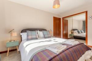 a bedroom with a large bed and a mirror at 3 Bed in Strathkanaird oc-r30948 in Ullapool