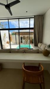 a living room with a couch and a large window at Arenas Blancas VILLA 1 in Uluwatu