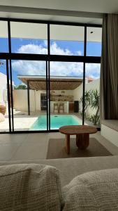 a living room with a table and a large window at Arenas Blancas VILLA 1 in Uluwatu
