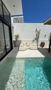 a house with a swimming pool next to a building at Arenas Blancas VILLA 1 in Uluwatu +16 photos