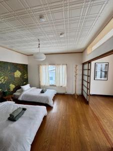 two beds in a large room with wooden floors at Blanco Escape in Myoko