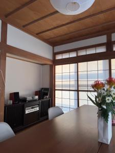 a dining room with a table with a vase of flowers at Blanco Escape in Myoko +17 photos