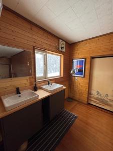 a bathroom with two sinks in a wooden wall at Blanco Escape in Myoko