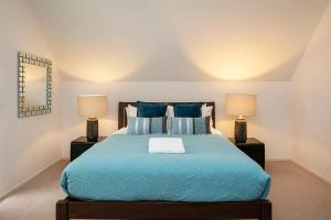 a bedroom with a blue bed with two lamps at Apt 9 'Delphinius' @ Bay View Centro, Dunsborough in Dunsborough