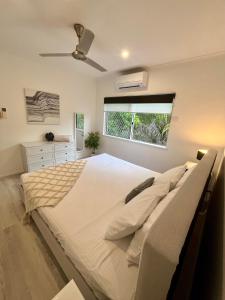 a bedroom with a large bed and a window at The Lazy Break at Trinity in Trinity Beach