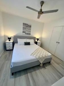 a bedroom with a bed and a ceiling fan at The Lazy Break at Trinity in Trinity Beach