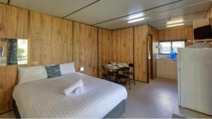 a bedroom with a bed and a kitchen with a table at BIG4 Barham Holiday Park in Barham