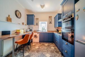 a kitchen with blue cabinets and a washer and dryer at 2 Bed in Moffat oc-a32121 in Moffat