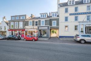 a street with cars parked in front of buildings at 2 Bed in Moffat oc-a32121 in Moffat
