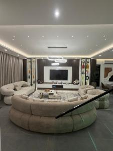 ein Wohnzimmer mit einer großen Couch und einem Fernseher in der Unterkunft Cresent Homes in Accra