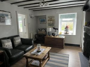 a living room with a couch and a coffee table at Tyddyn Serri in Rhosneigr