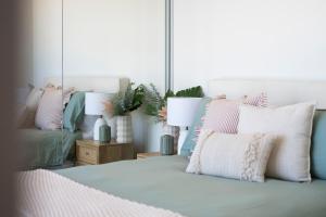 a bedroom with a bed with pillows and a couch at 1010 - Elite Escape - Absolute Beachfront Luxury in Newcastle