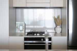 a kitchen with a stove and a vase with a plant at 1010 - Elite Escape - Absolute Beachfront Luxury in Newcastle