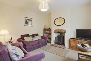 a living room with purple couches and a fire place at 2 Bed in Southwold oc-aathco in Southwold