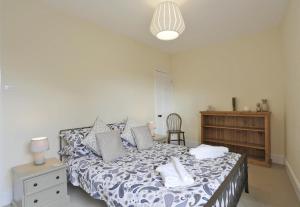 a bedroom with a bed with a blue and white comforter at 2 Bed in Southwold oc-aathco in Southwold