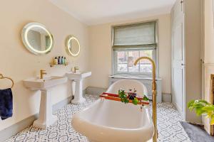 a bathroom with a large tub and two sinks at 5 Bed in Sedlescombe oc-l27505 in Sedlescombe +22 photos