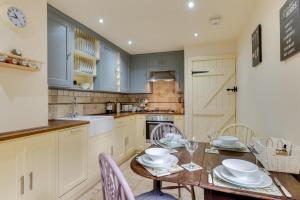 a kitchen with a table and chairs and a kitchen with white cabinets at 3 Bed in Hope Valley oc-dcherb in Eyam
