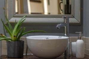 a sink in a bathroom with a mirror and a plant at 3 Bed in Hope Valley oc-dcherb in Eyam