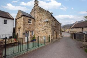 an old stone building with a fence around it at 3 Bed in Hope Valley oc-dcherb in Eyam