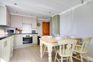 a kitchen with a wooden table and chairs at 2 Bed in Holt oc-1449 in Holt +6 photos